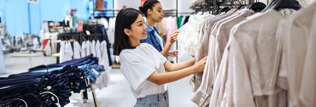 Women choosing clothes in clothing retail store