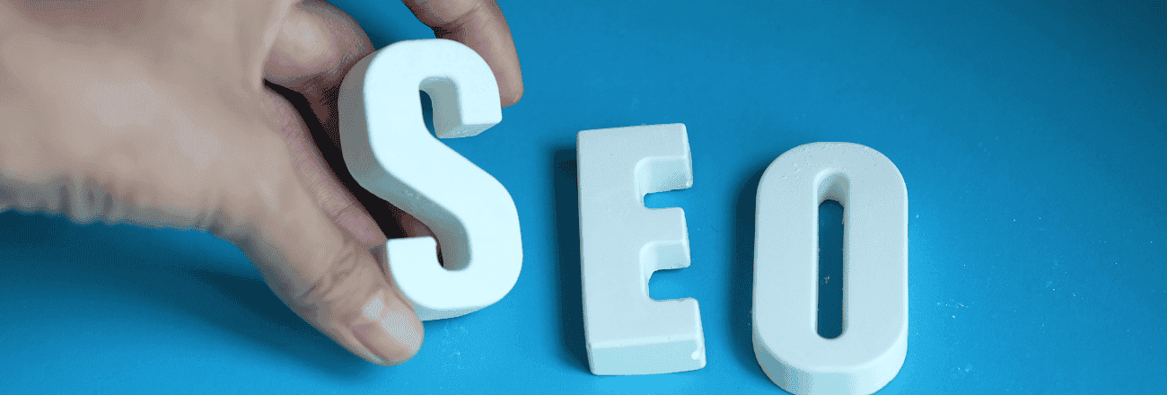 Hand holding 'SEO' letters, representing search engine optimization